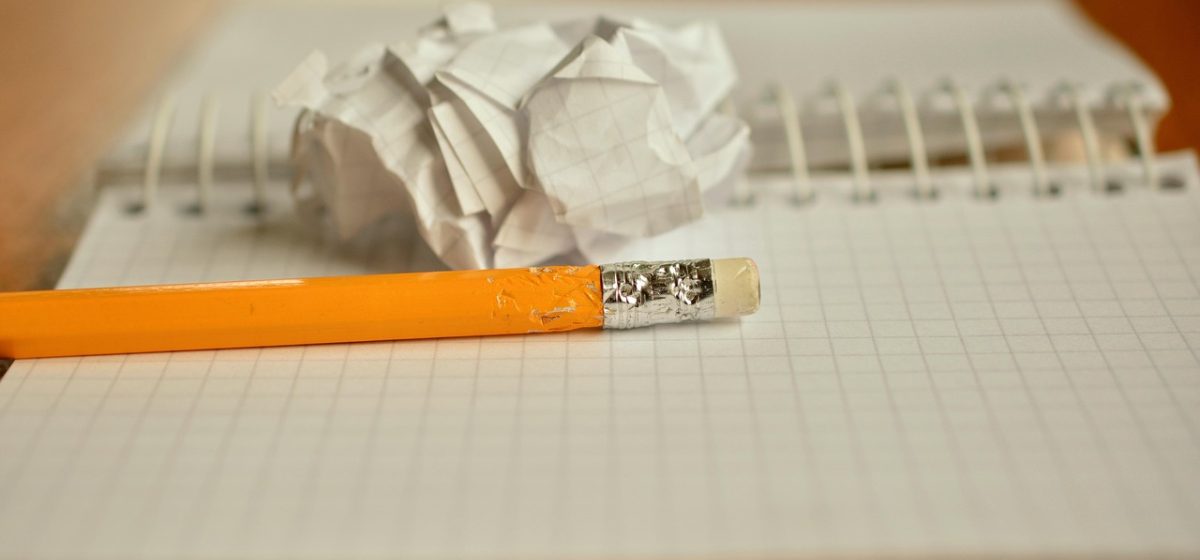 桌面上摊开的专业目录纸质版与笔记本并排放置，旁边用彩笔圈出专业大类归属，画面有学习备考的专注氛围